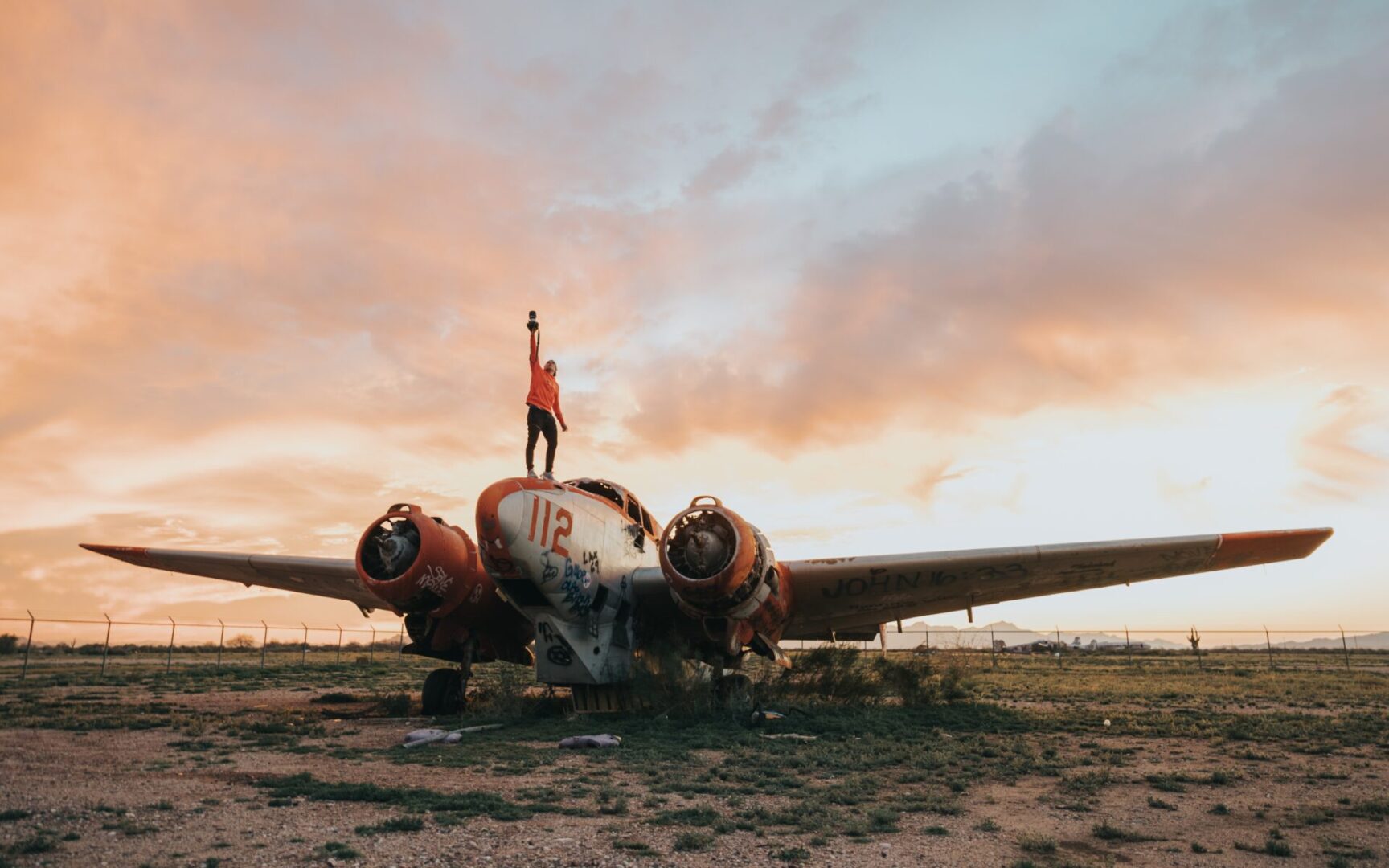 A man standing on the wing of an airplane.